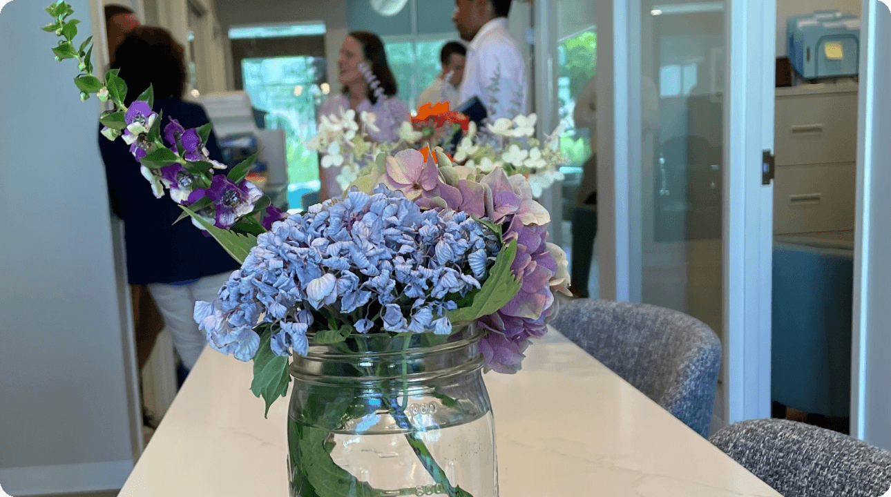 picture of a vase of pink and purple flowers on the LEAF conference room table